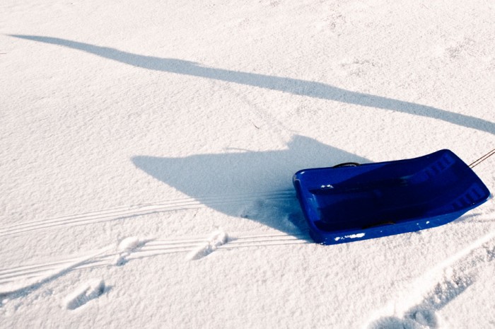 sled in snow long shadows